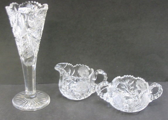 THREE AMERICAN BRILLIANT CUT CRYSTAL TABLE ACCESS: THREE AMERICAN BRILLIANT CUT CRYSTAL TABLE ACCESSORIES. One is a fluted vase in the hobstar pattern, 10 in. ht.; together with a cut and engraved cream and sugar set, floral pattern. C.1900. (Martha L
