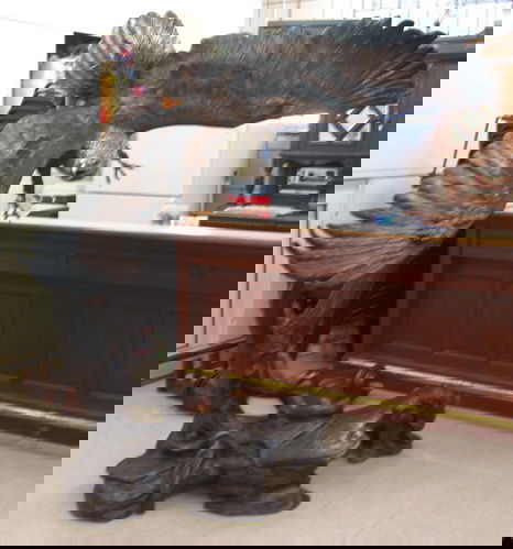 A LARGE BRONZE WILDLIFE SCULPTURE, a majestic Ame: A LARGE BRONZE WILDLIFE SCULPTURE, a majestic American bald eagle in flight over a bronze tree trunk pedestal base, the eagle having a silver-gilt head and tail feathers, gold beak and claws, red and