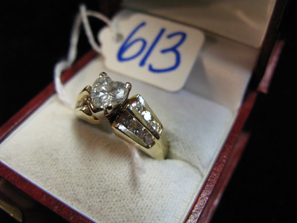 DIAMOND AND FOURTEEN KARAT GOLD RING, centering a