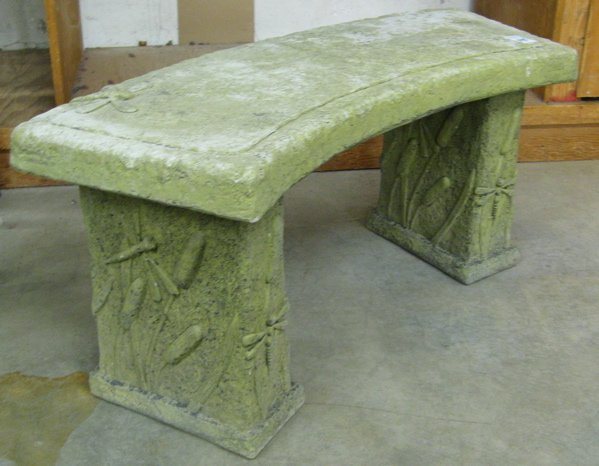A CAST CONCRETE GARDEN BENCH, the curved seat and