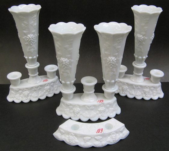 A GROUP OF FOUR WESTMORELAND GLASS CO. CANDLEHOLD: A GROUP OF FOUR WESTMORELAND GLASS CO. CANDLEHOLDERS/EPERGNES, all-white, vintage grape pattern. Two are fitted with two fluted vases; another a 3-candle holder; together with a curved2-candleholder,