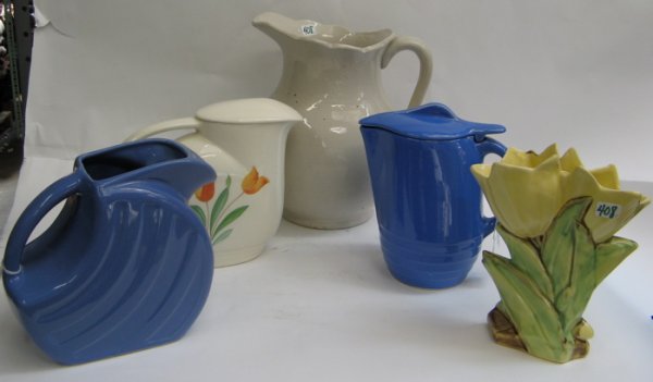 FIVE AMERICAN POTTERY TABLE ACCESSORIES. One is a: FIVE AMERICAN POTTERY TABLE ACCESSORIES. One is a McCoy figural tulip vase, painted with green leaves, marked McCoy underfoot, 8 in. ht.; 2 blue unsigned pitchers (one with a lid); a white Knowes Util