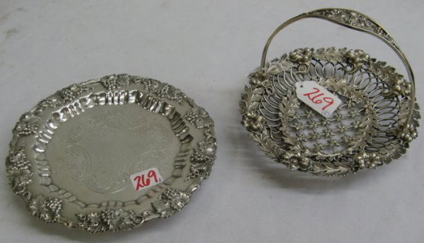 TWO SILVER PLATED TABLE ACCESSORIES. One is a She: TWO SILVER PLATED TABLE ACCESSORIES. One is a Sheffield wine coaster, vintage grape and vine band with engraved center, with handle, 6-1/2 in. dia.; together with a filigreed calling card basket, flor