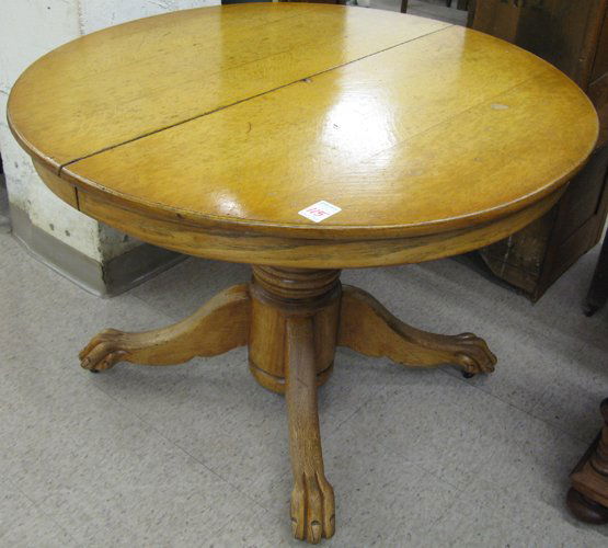 ROUND OAK PEDESTAL DINING TABLE AND FOUR CARVED O: ROUND OAK PEDESTAL DINING TABLE AND FOUR CARVED OAK HALL CHAIRS, American, c. 1900. The chair set has matching seat and leg designs but hand crafted using three different back designs: a pair of north