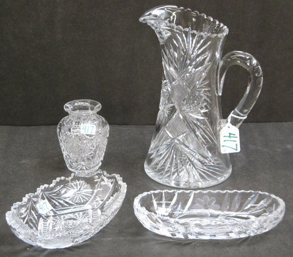 FOUR AMERICAN CUT CRYSTAL TABLE ACCESSORIES. One i: FOUR AMERICAN CUT CRYSTAL TABLE ACCESSORIES. One is a water pitcher in a hobstar pattern, 9-3/4 in.; a posy vase, 4-1/4 in.; and 2 relish dishes, each 7-3/4 in. length, C. 1900.