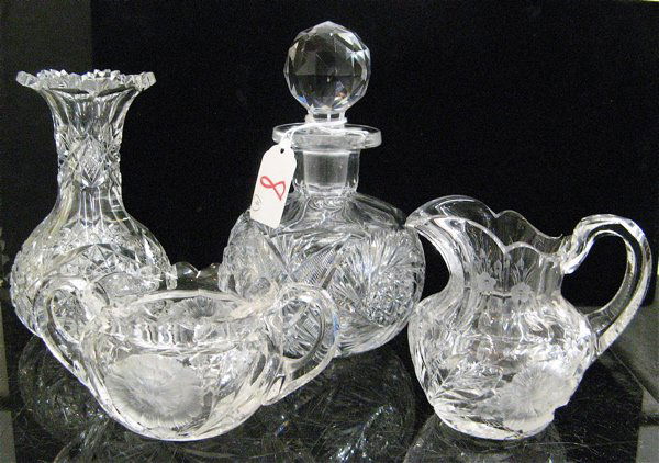 FOUR AMERICAN CUT CRYSTAL TABLE ACCESSORIES. One is: FOUR AMERICAN CUT CRYSTAL TABLE ACCESSORIES. One is an oil and vinegar bottle with original faceted stopper; a small vase, and a cream and sugar set. C. 1900.