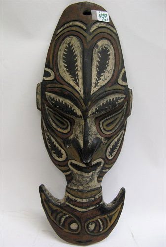 FOUR HAND CARVED WOODEN ITEMS. Three are African: FOUR HAND CARVED WOODEN ITEMS. Three are African: wall mounted mask-like carving with downturned nose, traces of pigments, 8 in. by 18 in.; a wall plaque with raised hut, trees and figures heightened