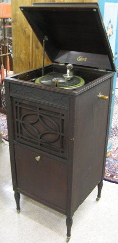EDISON DISC PHONOGRAPH, floor model C-150 "Sherat: EDISON DISC PHONOGRAPH, floor model C-150 "Sheraton," SM-113645, c. 1915-1919, having a lift-top mahogany floor cabinet with speaker grill over double door record storage cabinet filled with records.