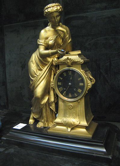 GOLD SPELTER STATUE CLOCK, French, late 19th cent: GOLD SPELTER STATUE CLOCK, French, late 19th century, lady and pedestal surmounting a rectangular black slate plinth, the pedestal housing a round, brass, time & bell strike movement with JAPY FRERES