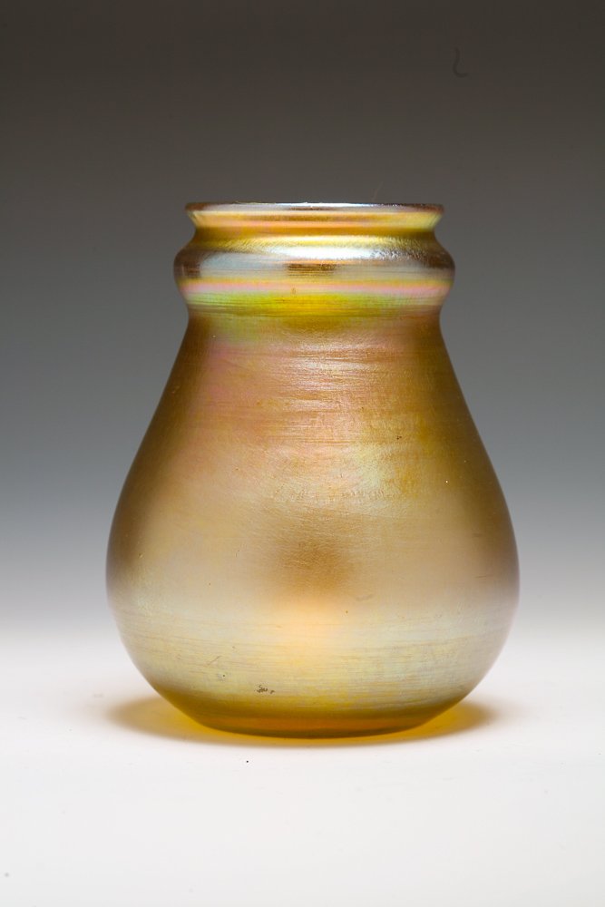 Tiffany Favrile Glass Aurene Cabinet Vase: A Tiffany Favrile glass gold iridescent, wide bodied and ringed vase with multi colored highlights, signed on bottom "94 L.C.Tiffany Favrile". Applied pontil mark in the Tiffany style.Dimensions to fo