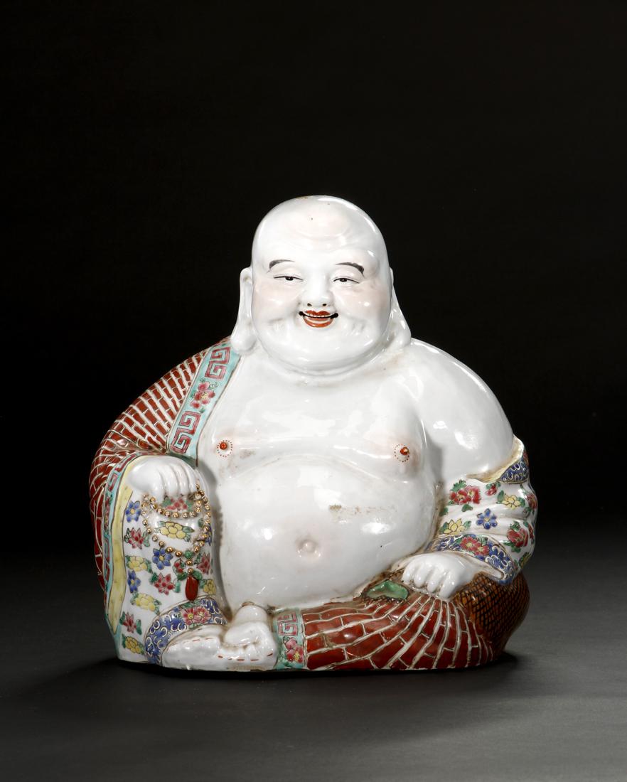 Chinese Famille Rose Figure of Budai: Budai is modelled seated with his legs crossed and with a string of prayer beads in his right hand. His robe falls open at the chest exposing his full belly, the unglazed base with a square four-chara