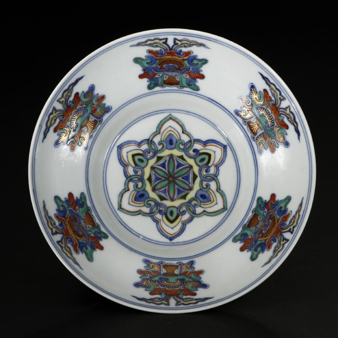 Chinese Doucai Ogee Bowl: Finely decorated in the doucai palette with famille-rose highlights,the interior painted with a floral medallion encircled by six identical emblems, the exterior densely decorated with stylized floral