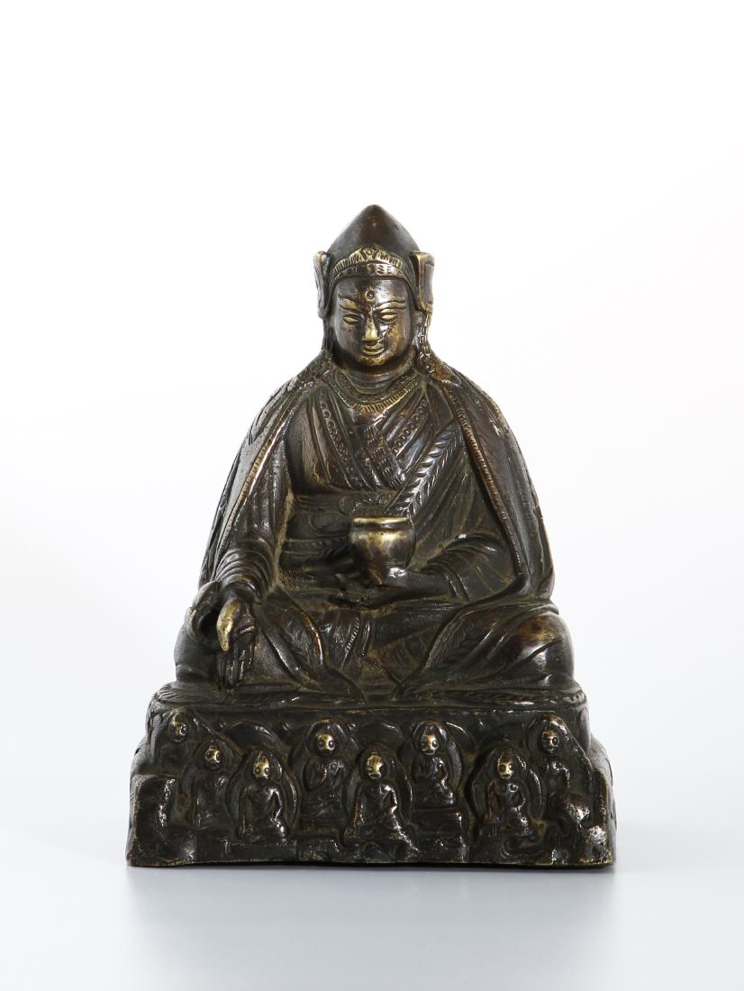 Gilt-Bronze Figure of Medicine Buddha: The Buddha is seated in dhyanasana on a lotus base, with the left hand in dhyanamudra holding a bowl, and the right hand extended in varadamudra, holding a single myrobalan fruit. The figure wears lay