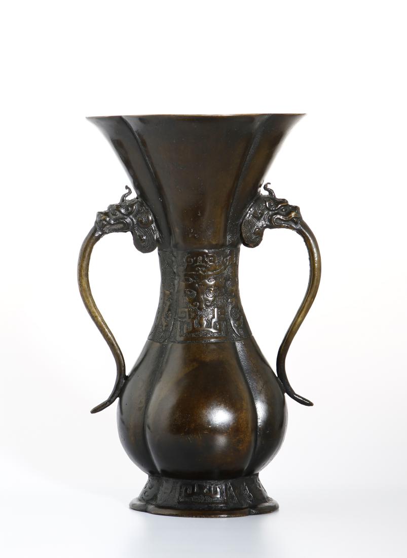 Chinese Bronze 'Taotie' Vase: Cast in petal-lobed yenyen form rising from a short splayed foot to a swelling body and trumpet mouth, flanked by a pair of loops gushing out of dragon's jaws retaining large mobile rings. Height 11 1
