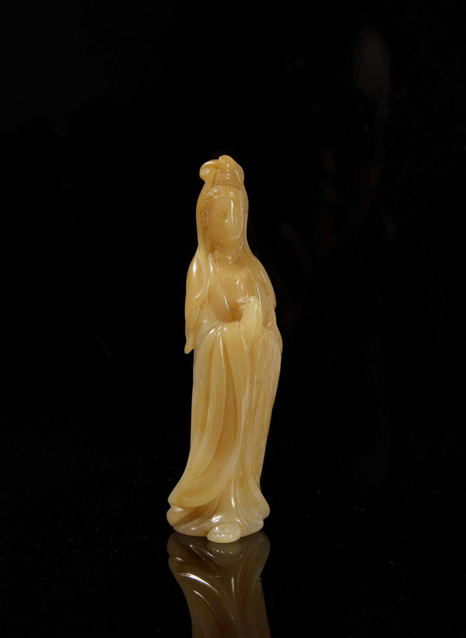 Chinese Yellow Jade Figure of Guanyin: Depiciting a figure of Guanyin, wearing a long robe and hands in held in anjali mudra, the stone of rich brownish yellow tune. Height 3 1/2 in.