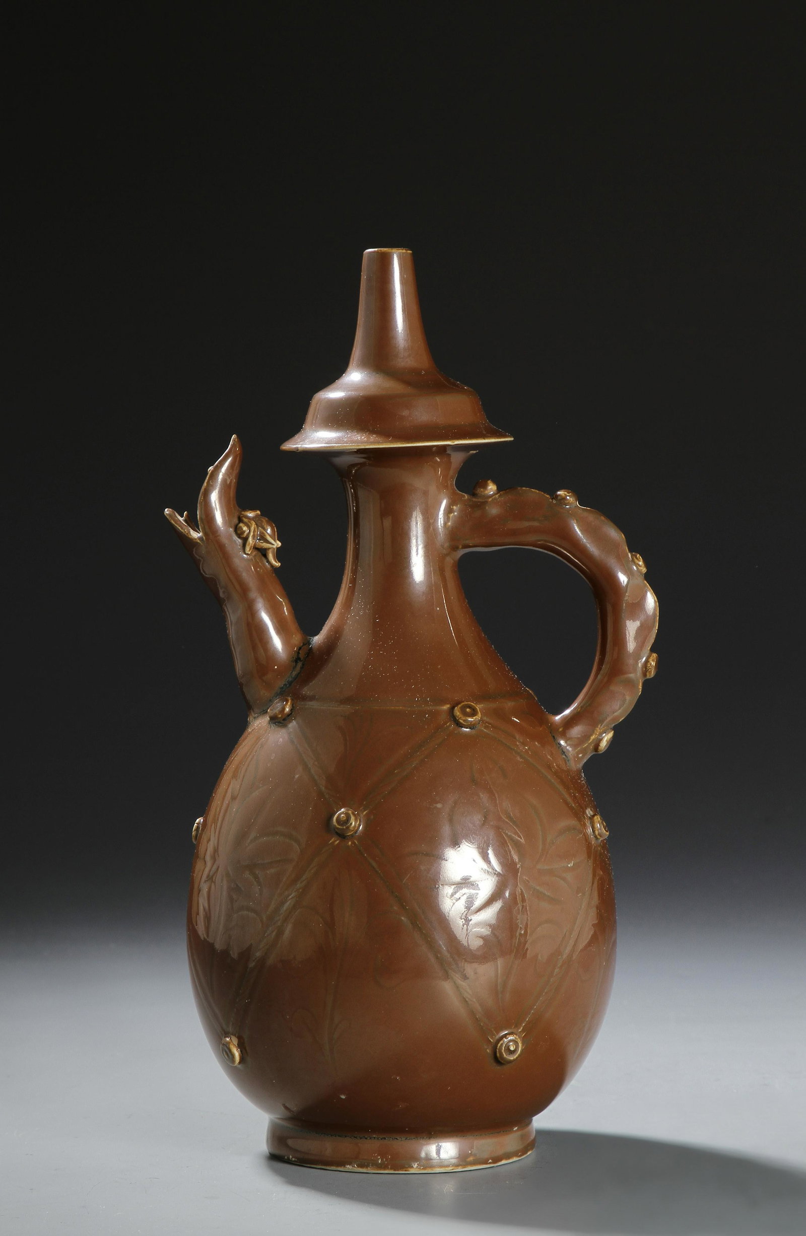 Persimmon Glazed Liao Ting-Type Ewer: The ovoid body tapering to a waisted neck collared with a cap like flange surmounted to a pointed mouth,_x000D_ set to the shoulder with an upright spout with monster mouth opposite a loop handle, the