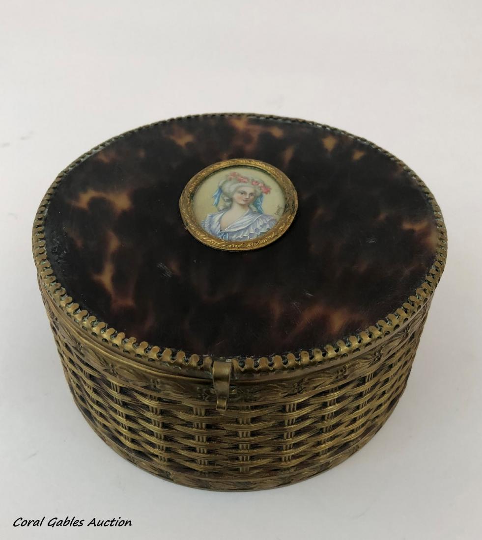 Bronze and tortoiseshell box with a hand painted: Bronze and tortoiseshell box with a hand painted plaque. Measure 2 1/2"in H x 5 1/2"in diameter.
