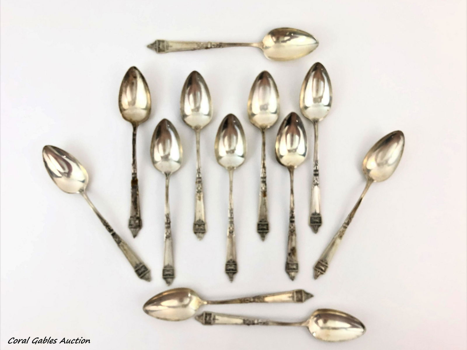 Twelve signed sterling silver dessert spoons: Twelve signed sterling silver dessert spoons. Measure 5 1/2"in W.