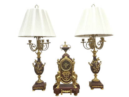 19th Century French Gilt Bronze & Marble Clock Garniture Set with Candelabra Lamps: Elegant 19th century French three-piece garniture set comprising a central mantel clock and a pair of converted candelabra lamps. The clock is crafted from rouge marble and gilt bronze, featuring orna