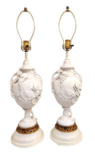 Pair of Vintage White Bisque Porcelain Lamps with Grape Relief and Gilt Accents: Charming pair of vintage bisque porcelain table lamps featuring raised relief decoration of grape clusters and vines in a matte white finish. The openwork urn-shaped bodies sit atop rounded bases with