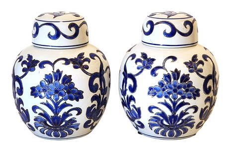 Pair of Blue and White Ceramic Ginger Jars with Floral Motif: A decorative pair of blue and white ceramic ginger jars featuring a classic floral design in deep cobalt blue glaze. These lidded jars are adorned with hand-painted blossoms and scrolling foliage on a