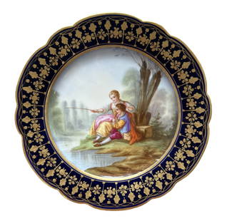 French Sevres Hand-Painted Porcelain Plate with Cobalt Border, Signed Boucher: Elegant French Sevres porcelain cabinet plate featuring a beautifully hand-painted romantic scene of a couple seated in a lush garden landscape. The finely detailed artwork is signed "Boucher" on the