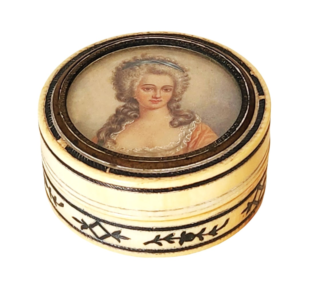 Antique Hand-Painted Miniature Portrait Snuff or Trinket Box in Original Case – Quintana y Ca.: A stunning antique round snuff or trinket box, finely crafted with what appears to be bone or faux ivory, and delicately hand-painted with a miniature portrait of a noble lady in 18th-century attire.