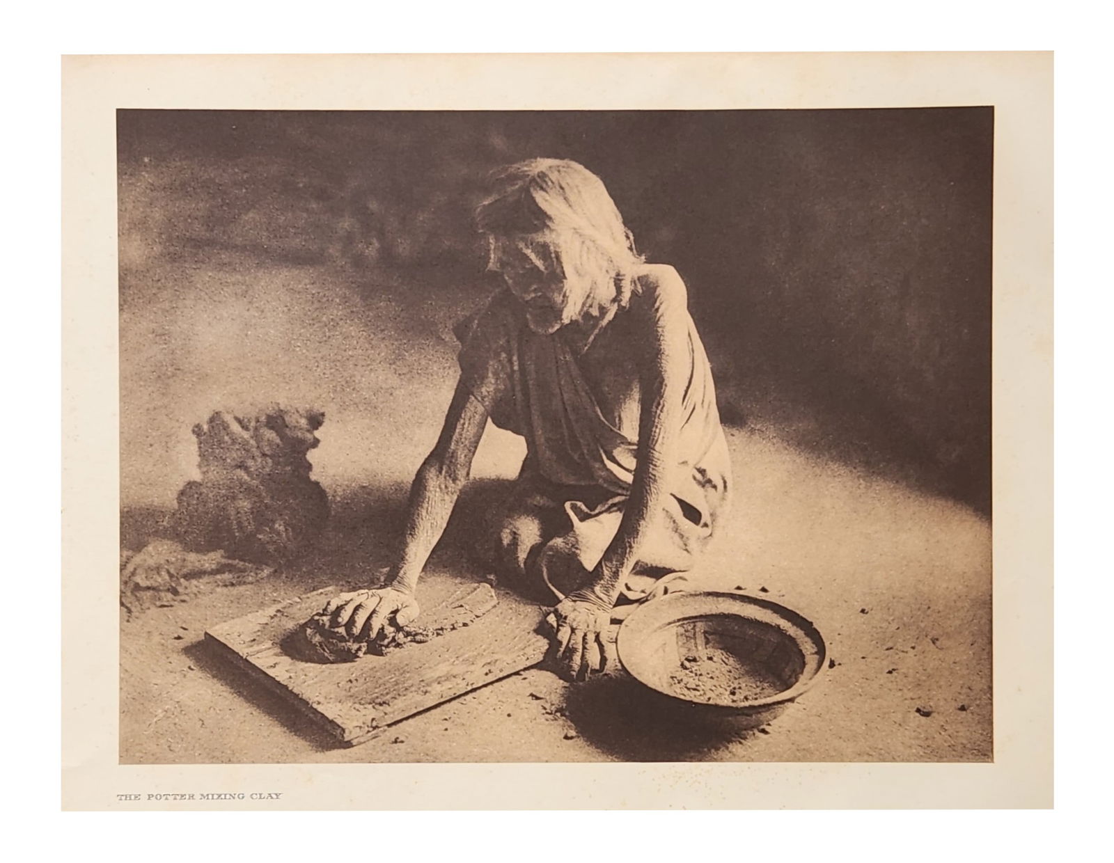 Edward Sheriff Curtis (1868 - 1952) American: Edward Sheriff Curtis (1868 - 1952) American Title: The Potter Mixing Clay Print Caption - Engraving Date: 1921 Measure 13"in H x 18"in W no framed This woman, so aged t