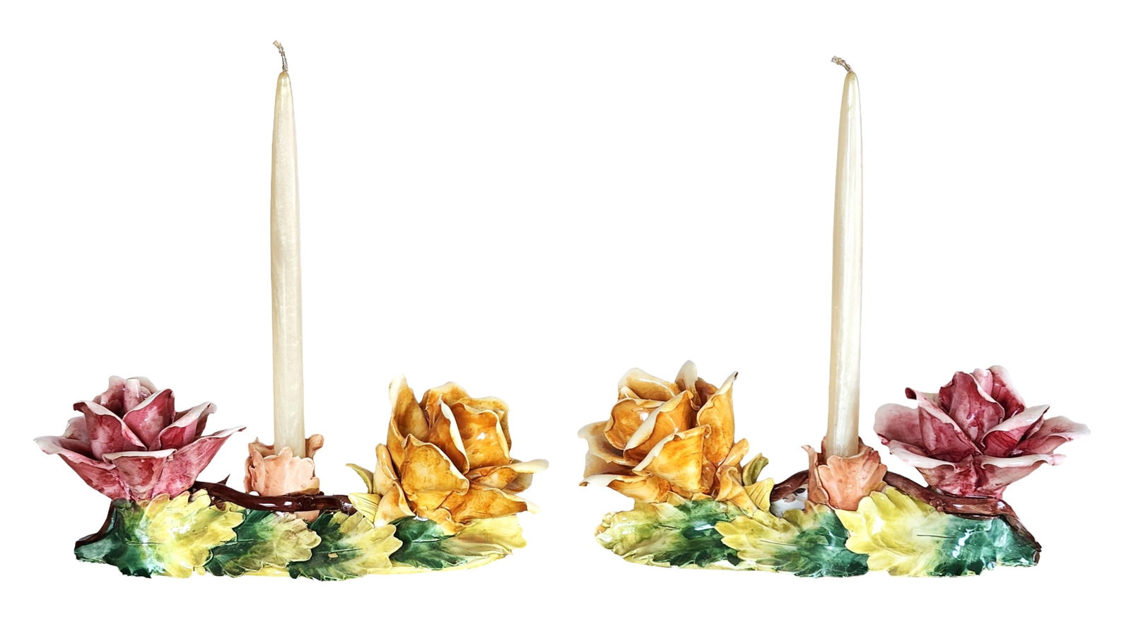 Pair of Capodimonte Floral Ceramic Candlesticks, Made in Italy: Charming pair of Capodimonte ceramic candlesticks, hand-modeled and hand-painted in Italy. Each candlestick features applied floral decoration with sculpted roses and foliage in soft pink, yellow, and
