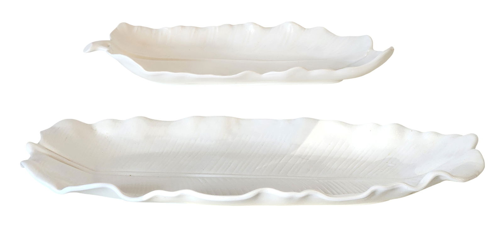 Pair of White Milk Glass Leaf Form Serving Dishes: Decorative pair of white milk glass serving dishes molded in an elegant leaf form with finely detailed veining and softly ruffled edges. The elongated shape and naturalistic design make them ideal for