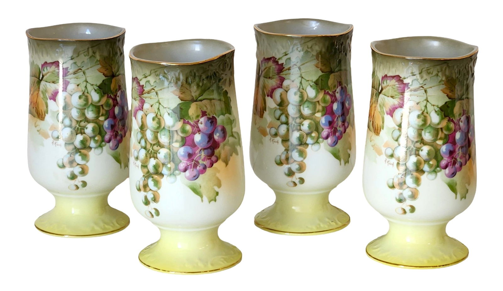 Set of Four Porcelain Grape-Decorated Goblets, Signed A. Koch: Group of four porcelain goblets decorated with grape and vine motifs, each bearing a visible decorator’s signature “A. Koch.” The goblets feature softly molded forms with pedestal bases, gil