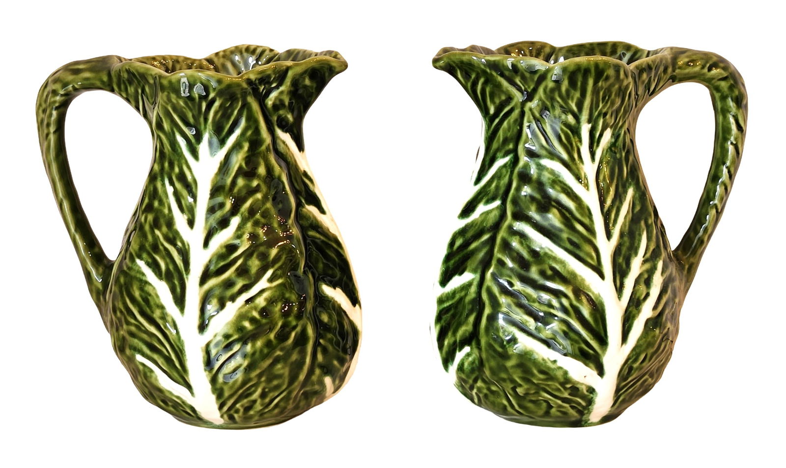 Pair of Portuguese Green Glazed Leaf-Form Jugs by Olfaire: A decorative pair of green glazed ceramic jugs, moulded in a naturalistic leaf-form design. Each jug is richly textured to resemble veined foliage, finished in a deep glossy green glaze with cream-col
