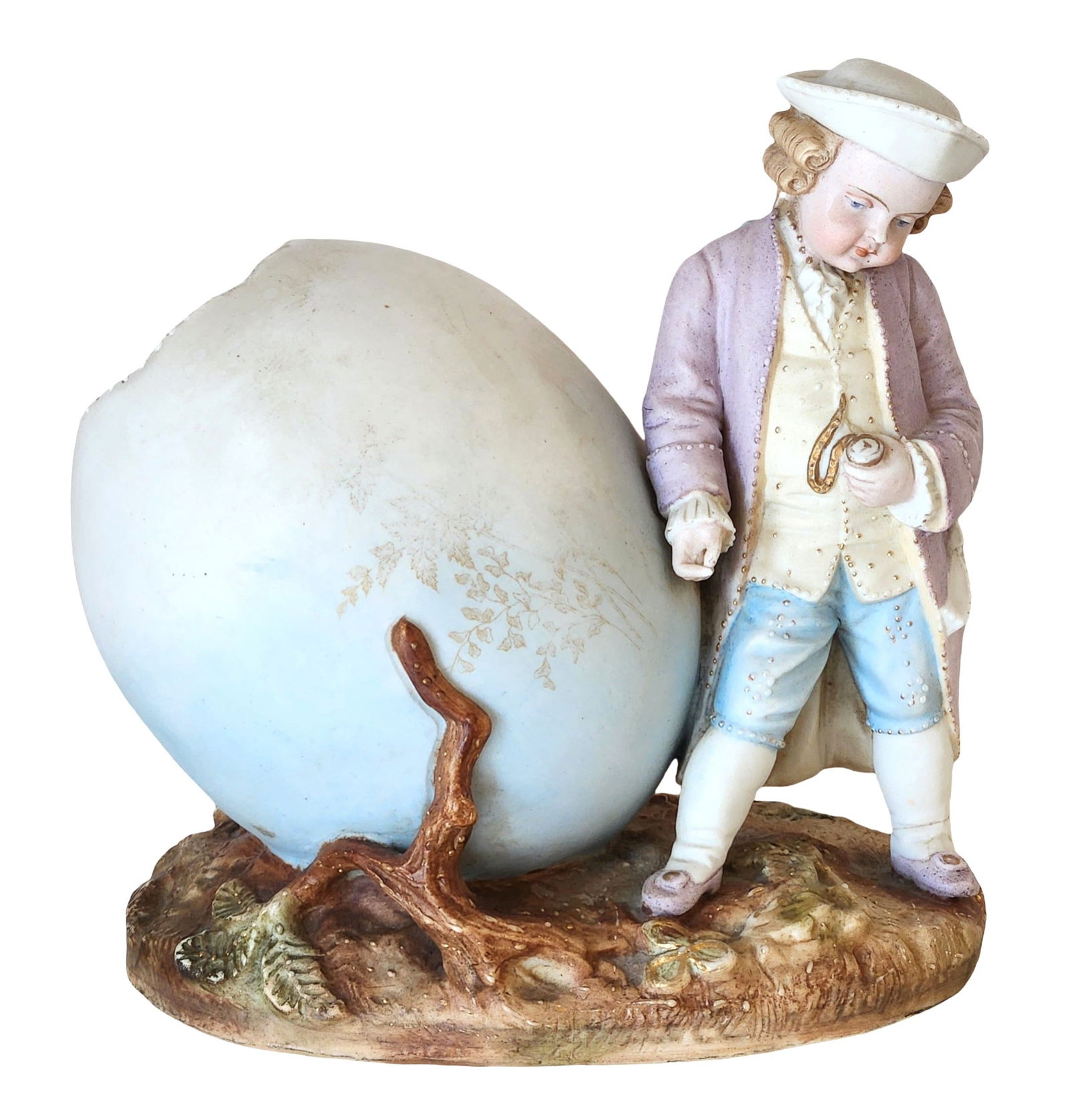 Antique German Porcelain Figural Vase / Planter – Boy with Egg Form Vessel, Budelstadt Mark: Antique German porcelain figural vase or planter depicting a finely modeled young boy in 18th-century attire standing beside a large egg-form vessel. The figure is delicately hand-painted in soft past