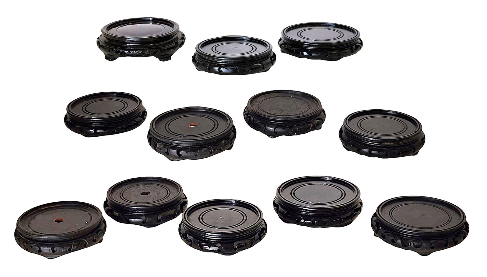 Collection of Chinese Carved Hardwood Display Stands, 19th–20th Century: A diverse group of Chinese carved hardwood display stands, dating from the late Qing dynasty to early 20th century. The collection includes circular, oval, and rectangular examples, with both pierced