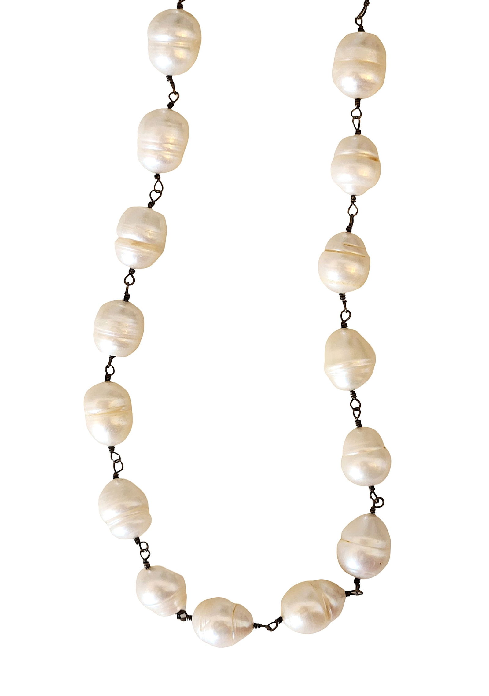 Baroque Freshwater Pearl Necklace with Sterling Silver Clasp: Elegant necklace composed of large baroque freshwater pearls featuring organic shapes and luminous nacre. The pearls display soft white to cream tones with natural surface texture and iridescent overt