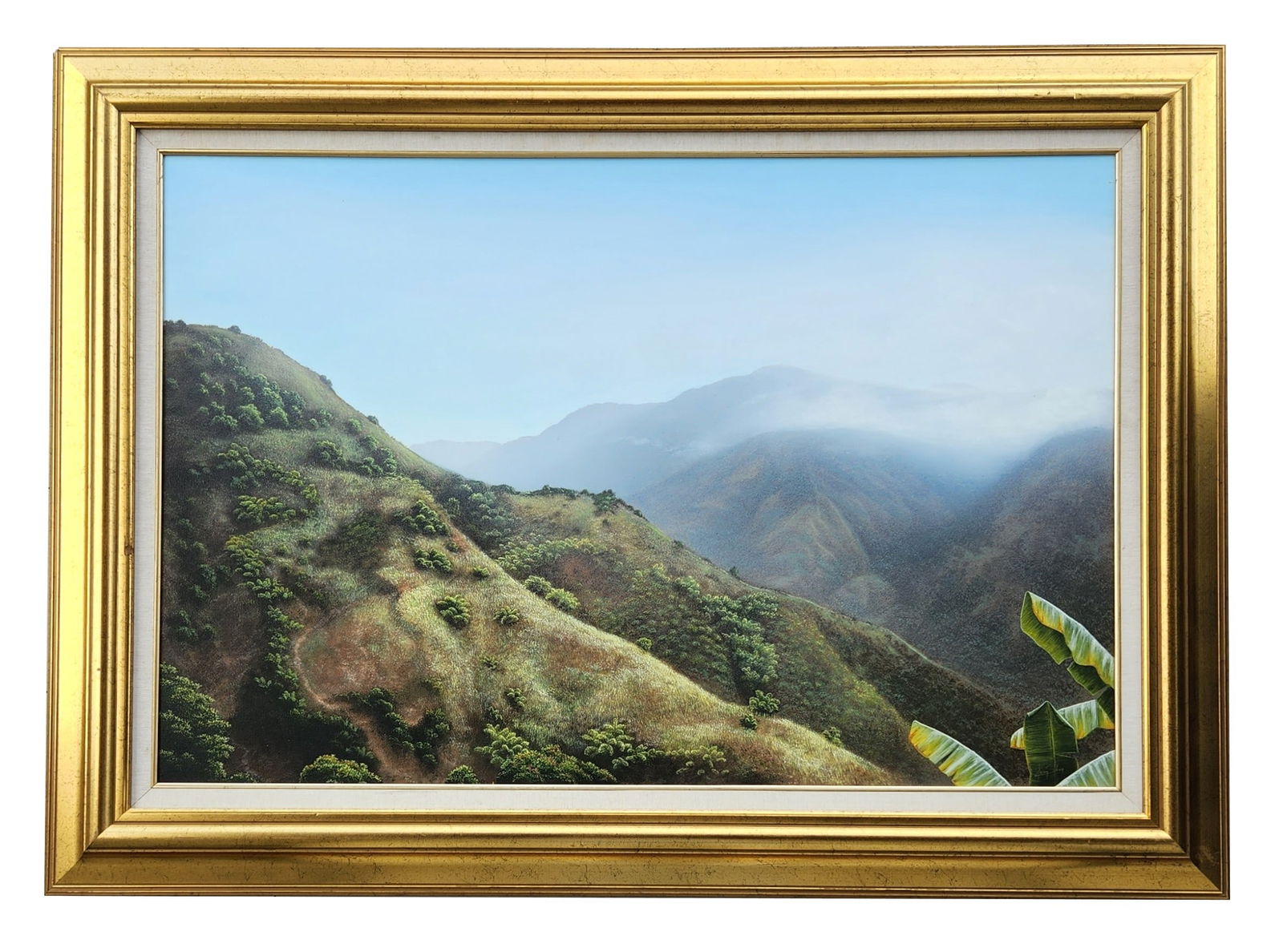 Caribbean Mountain Landscape Oil Painting, Illegibly Signed, in Gilt Frame: A striking and finely detailed Caribbean mountain landscape rendered in oil on canvas, featuring rolling green hills, atmospheric mist across distant peaks, and vibrant banana leaves in the foreground