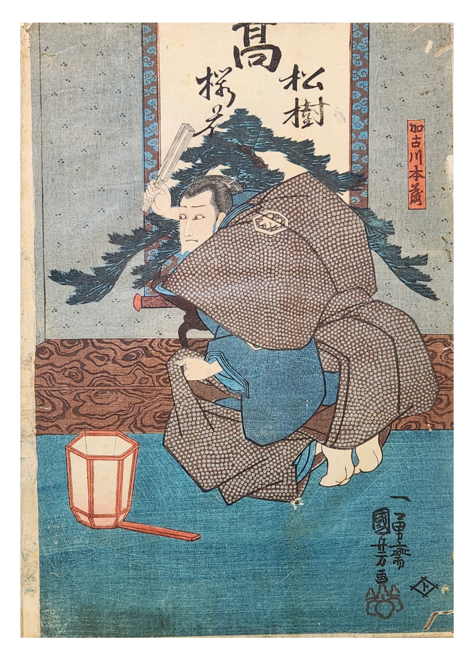 Japanese Ukiyo-e Woodblock Print of Kabuki Actor, Utagawa Kunisada (Toyokuni III), Edo Period: Japanese ukiyo-e color woodblock print depicting a kabuki actor in a dramatic kneeling pose within an interior setting. The figure holds a folded fan and wears patterned robes with a dotted outer garm