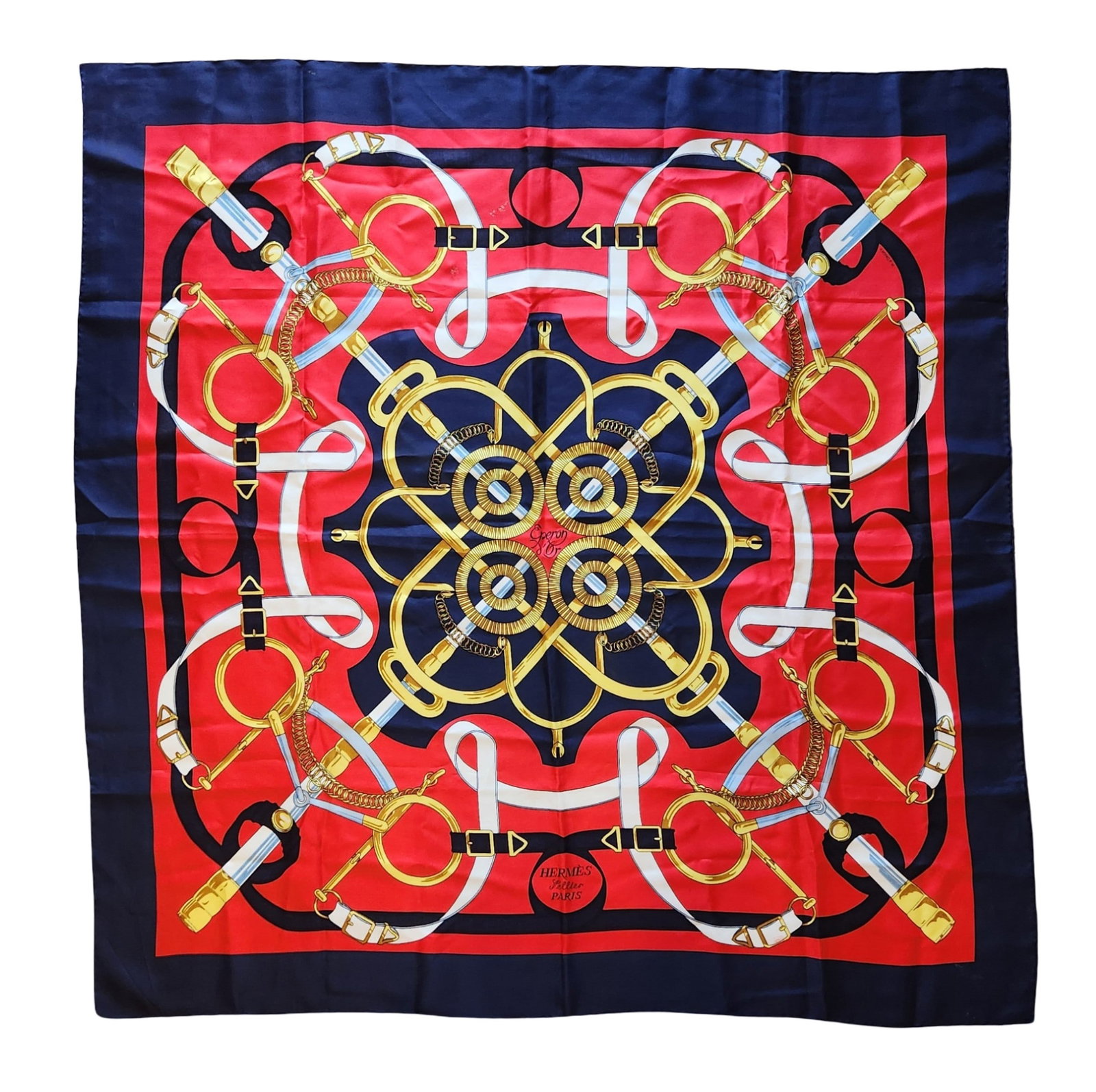 Hermès Silk Scarf with Equestrian Motif, Made in France: Hermès silk scarf featuring a bold equestrian-themed design with interlaced bridles, bits, and harness elements arranged in a symmetrical composition. Rendered in rich red, navy blue, gold, and white