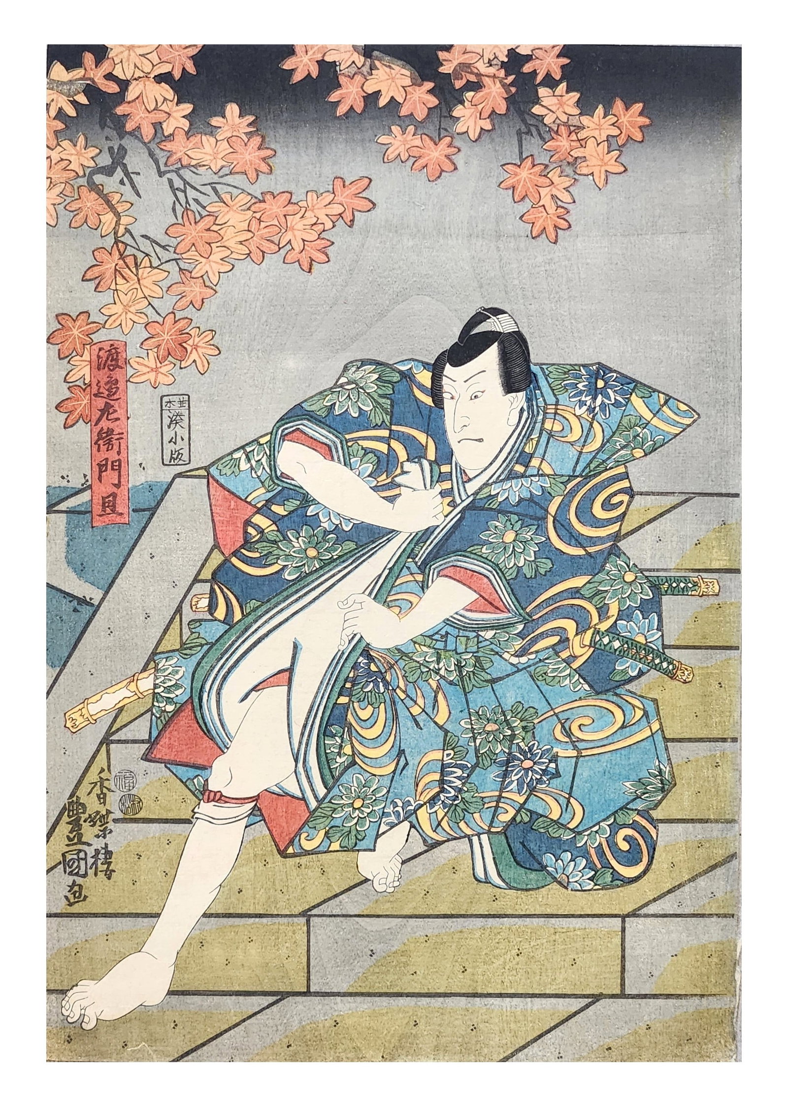Japanese Ukiyo-e Woodblock Print – Kabuki Actor Beneath Autumn Maple Leaves – Edo Period: Striking ukiyo-e woodblock print depicting a kabuki actor in a dynamic pose, set beneath cascading branches of autumn maple leaves. The figure is dressed in an elaborate robe decorated with bold flora