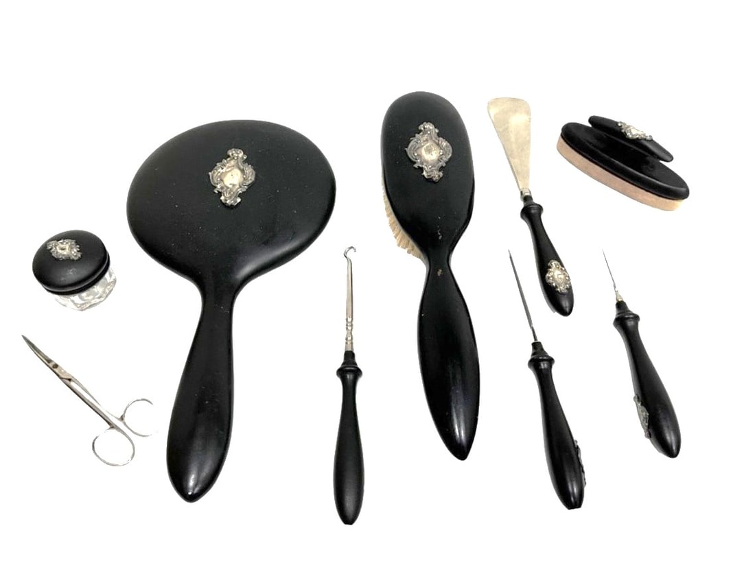 Antique English Silver and Faux Tortoiseshell Vanity Set ? 9 Pieces: Refined 9-piece English vanity set featuring silver-mounted faux tortoiseshell tops, delicately engraved with floral and ribbon garland motifs in silver inlay. The set includes three hair brushes, one