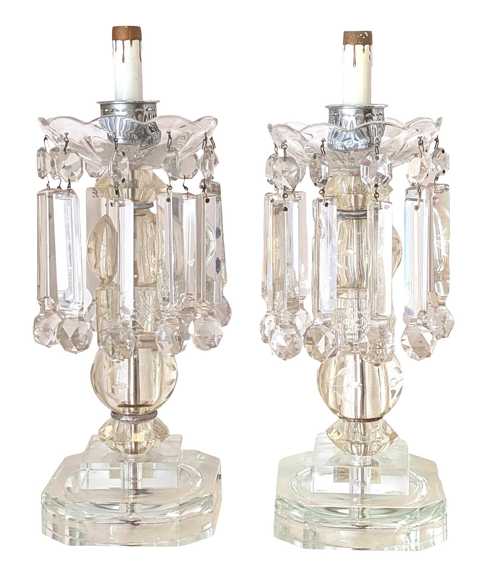 Pair of Cut Crystal Lustre Candlestick Lamps with Prisms and Acrylic Bases: Decorative pair of lustre-style candlestick lamps featuring cut crystal and glass construction with hanging prisms and faceted drops. Each lamp has a scalloped crystal bobeche supporting multiple susp