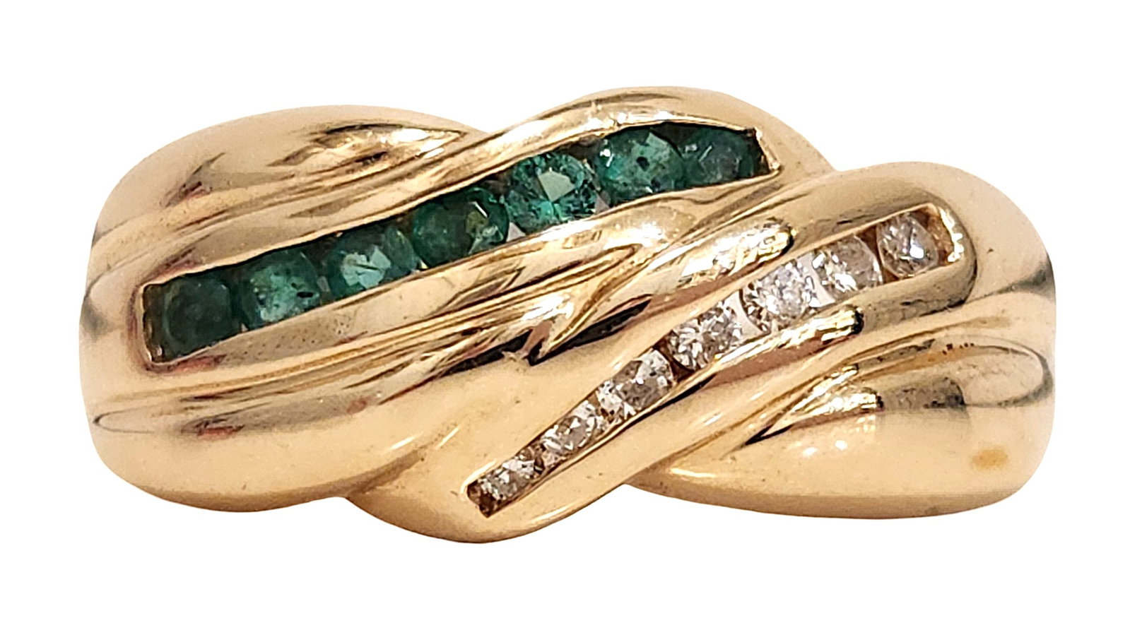 14K Yellow Gold Emerald and Diamond Wave Design Ring: Stylish 14K yellow gold emerald and diamond ring featuring a flowing wave design set with a row of round green emeralds and a parallel row of round brilliant accent diamonds. The stones are set in cha