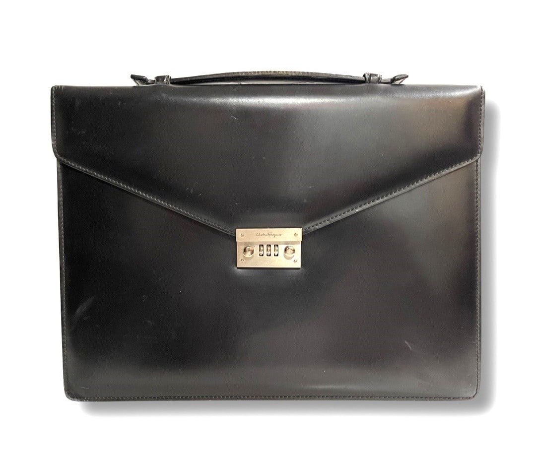 Authentic Salvatore Ferragamo Business Bag Black / 241067: Authentic Salvatore Ferragamo business bag crafted in smooth black leather with a structured, professional silhouette. This elegant briefcase features a front flap secured by a gold-tone engraved Ferr