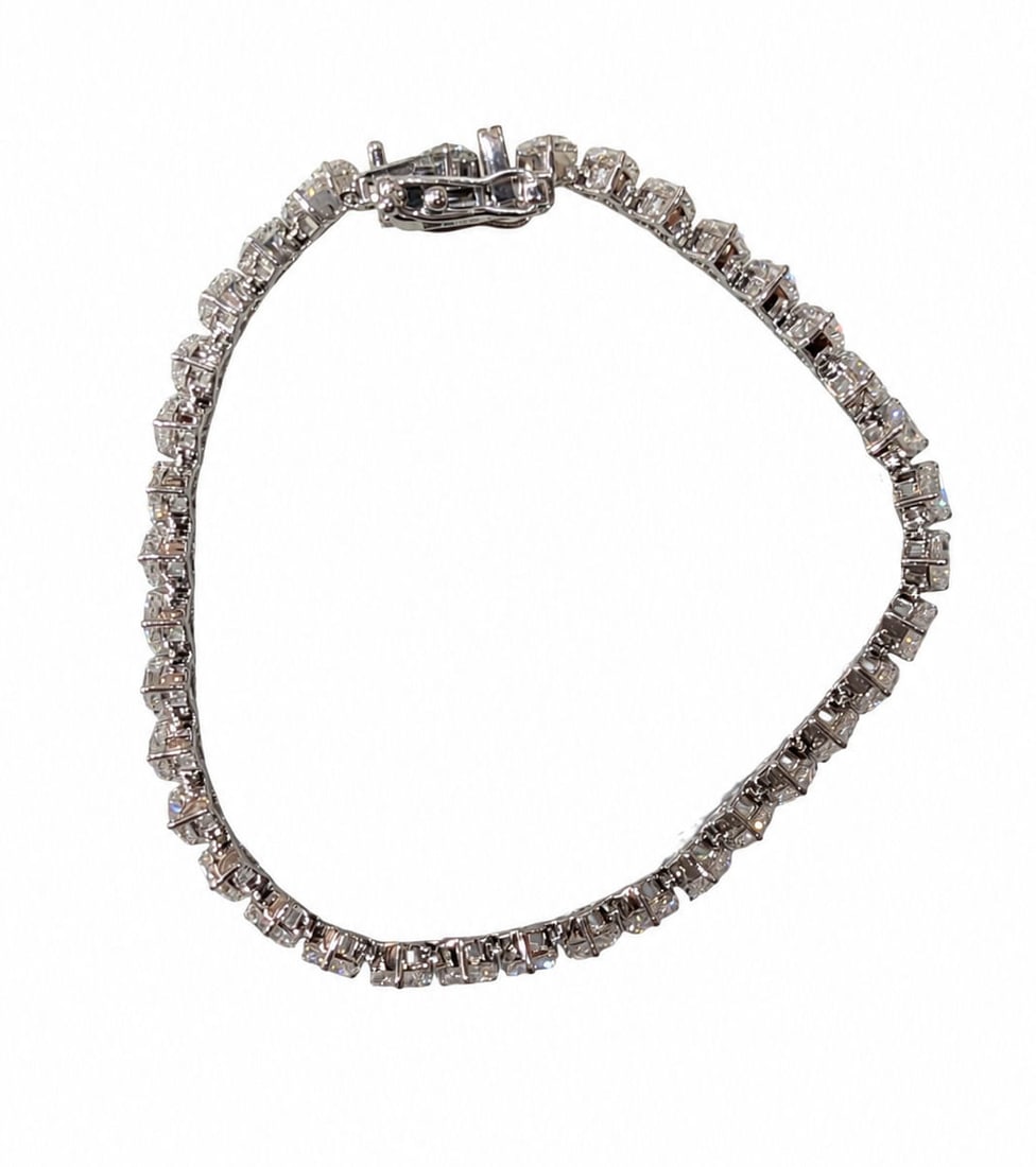14KT White Gold Heart Shape Diamond Tennis Bracelet, 9.47 CTW: Beautiful and elegant tennis bracelet crafted in solid 14KT white gold featuring a continuous row of sparkling heart-shaped diamonds accented with baguette and round diamond details throughout. This l