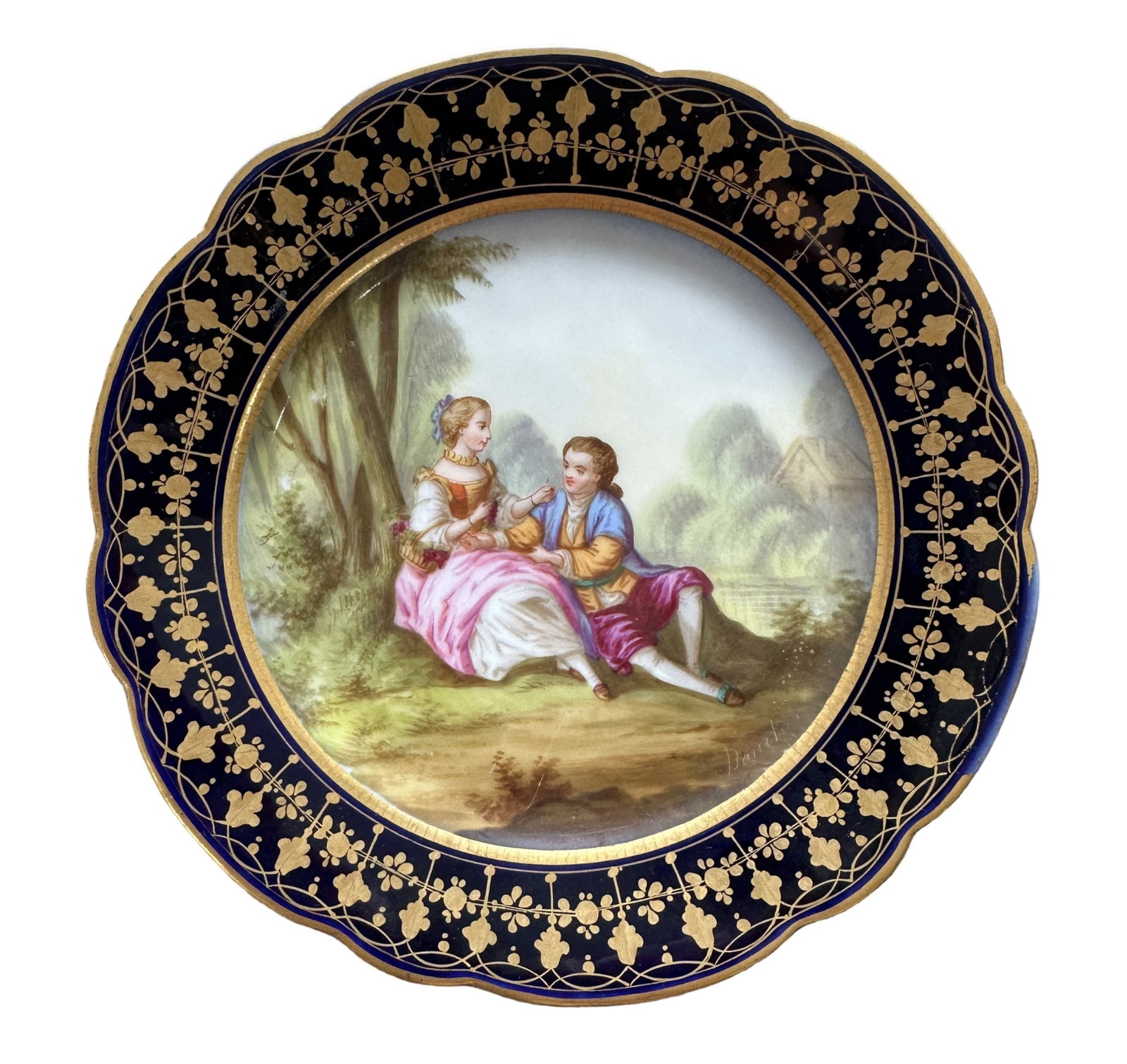 French Sevres Hand-Painted Porcelain Plate with Cobalt Border, Signed Boucher: Elegant French Sevres porcelain cabinet plate featuring a beautifully hand-painted romantic scene of a couple seated in a lush garden landscape. The finely detailed artwork is signed "Boucher" on the 