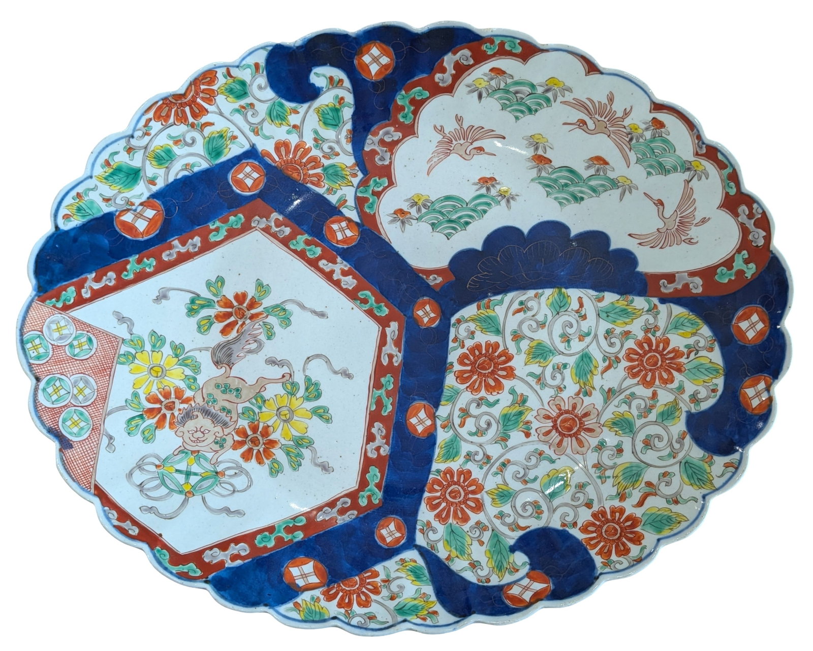 Large Japanese Imari Porcelain Scalloped Platter, Meiji Period Style: Large Japanese Imari porcelain serving platter of scalloped oval form, richly decorated in the traditional Imari palette of underglaze cobalt blue, iron red, green, and yellow enamels. The interior fe