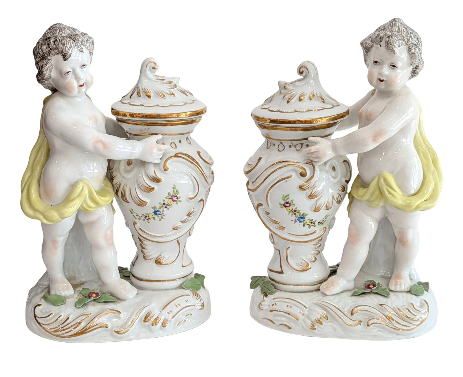 Antique European Porcelain Cherub Covered Urn Figurine Hand Painted Gilt Decor Anchor Mark: Charming antique European porcelain figural group featuring a cherub standing beside an ornate covered urn, beautifully decorated with hand-painted floral sprays, raised gilt scrollwork, and a soft ye