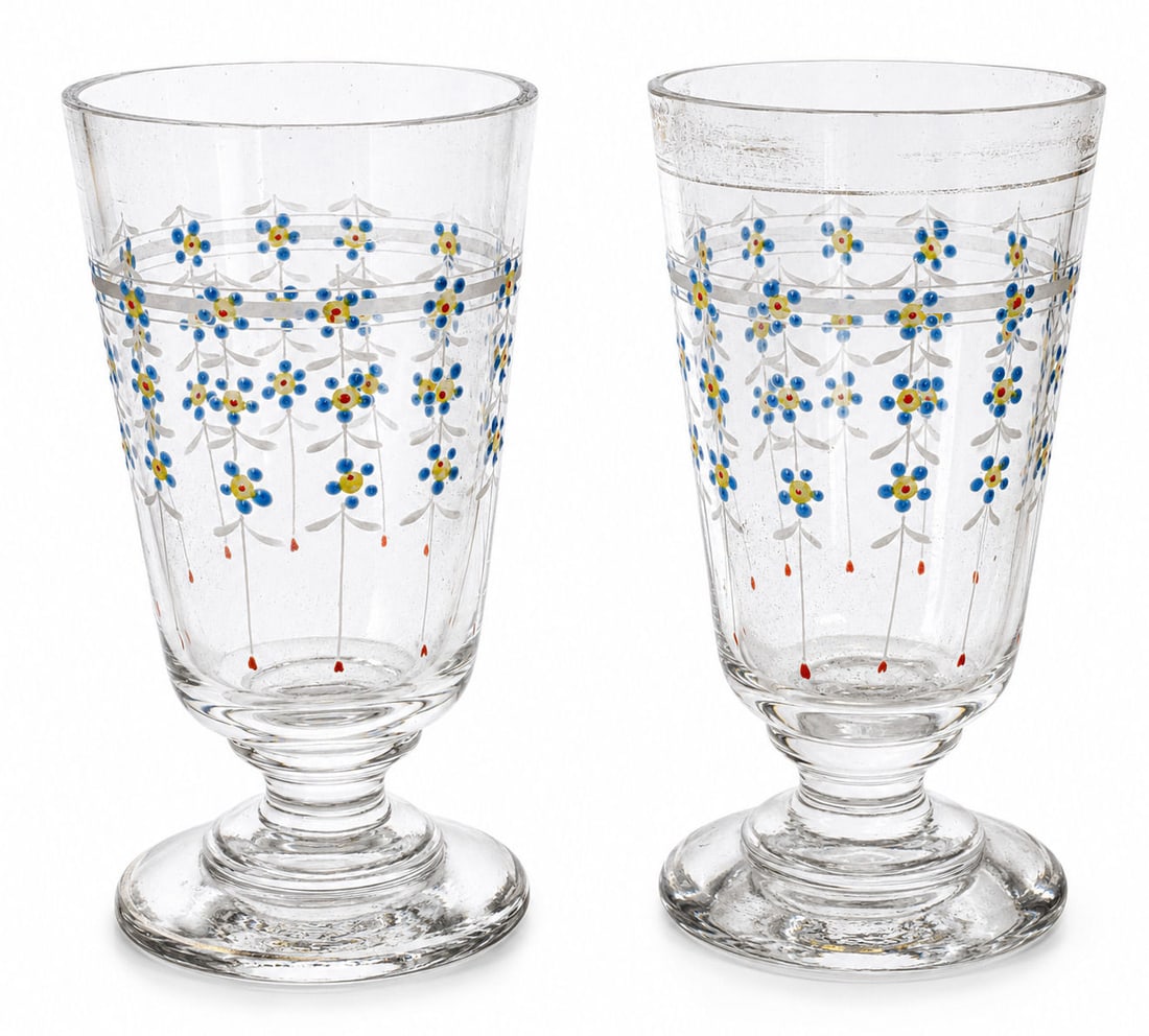 Pair of Antique Enameled Floral Glass Goblets: Charming pair of antique clear glass goblets featuring hand-painted floral enamel decoration in blue, yellow, white, and orange tones. Each glass is adorned with delicate hanging floral garlands accen