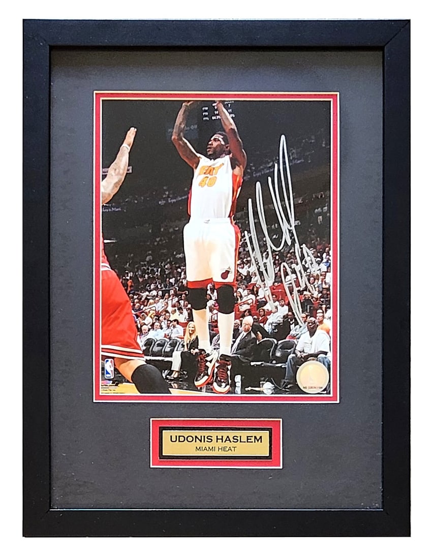 Udonis Haslem Signed Miami Heat Framed Photo NBA Certified Autograph: This framed photograph features Udonis Haslem, longtime Miami Heat forward and franchise legend, captured mid-shot during game action. The photo is hand-signed in silver marker and professionally matt
