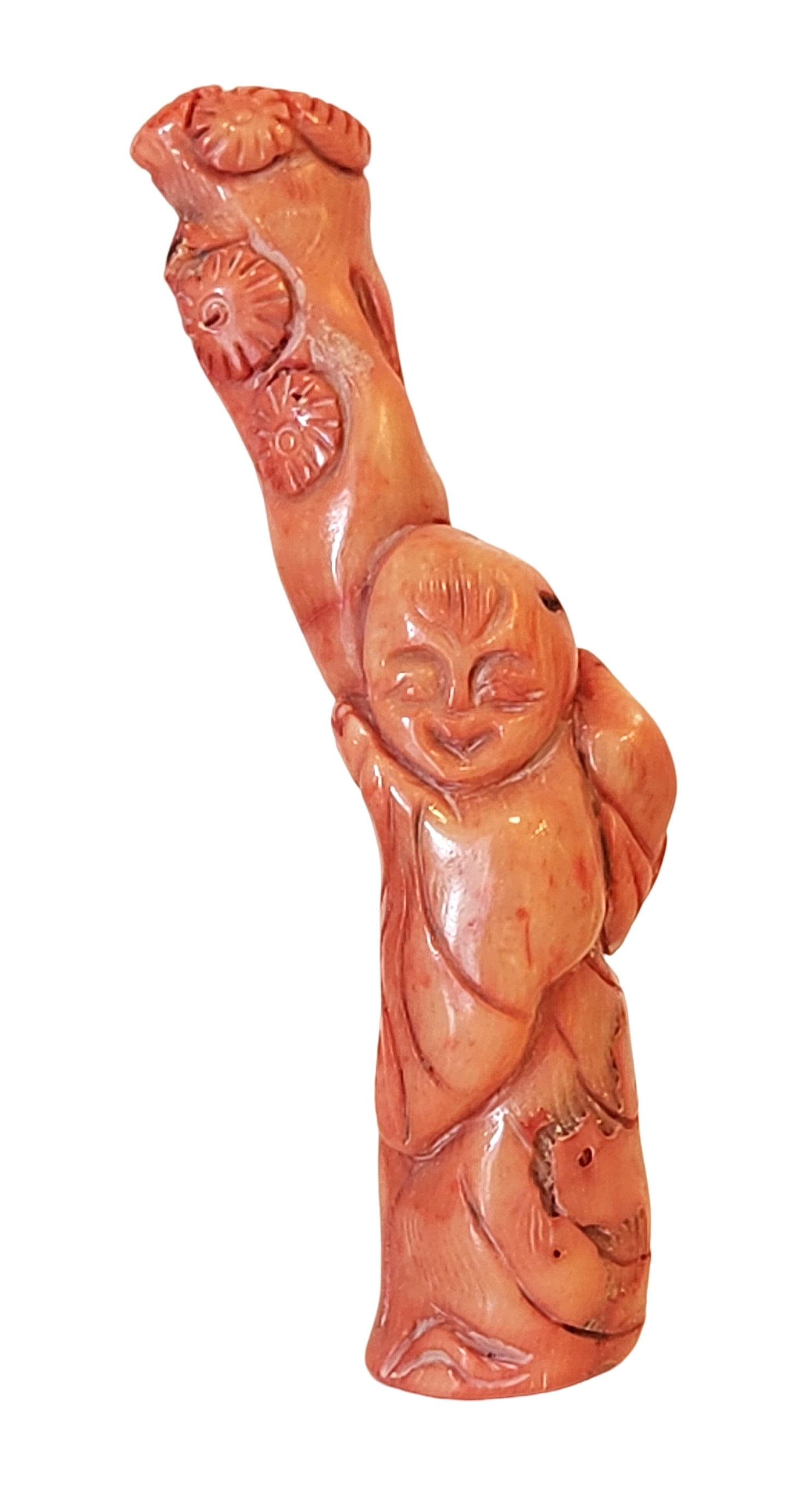 Antique Carved Red Coral Figure of a Laughing Immortal, Mid-20th Century: A Mediterranean red coral carving of a laughing immortal, worked from a natural coral branch. The figure is shown with detailed robes and expressive facial features, highlighted by the warm red-orange